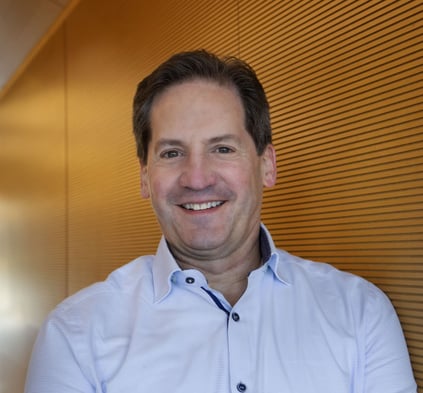 Photo description: Headshot of Gregory Sebasky in a blue button-down shirt