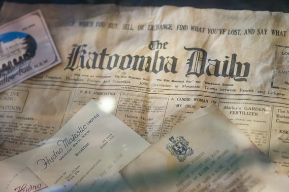 Photograph of old newspaper, business cards, and other historical documents